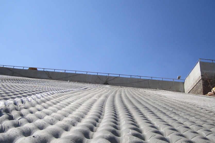 The geotextile, TechRevetment™ formed concrete mattresses, part of the geosynthetics solutions for erosion control. Pictured on the side of a dam.