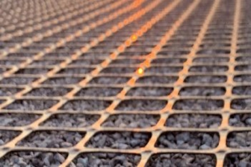 The geosynthetic, geogrid, ArmaGrid, filled with stones pictured on site at sunset.