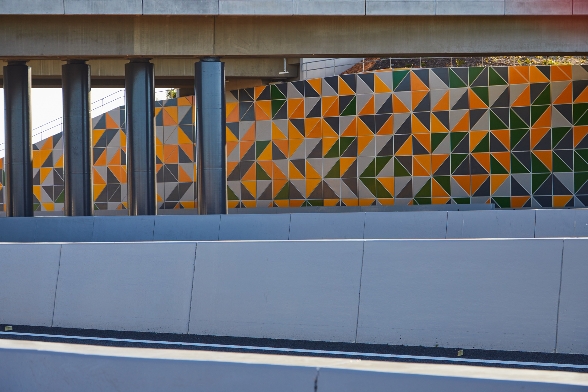 TerraTilt precast concrete retaining walls with coloured facade lining a new road highway.