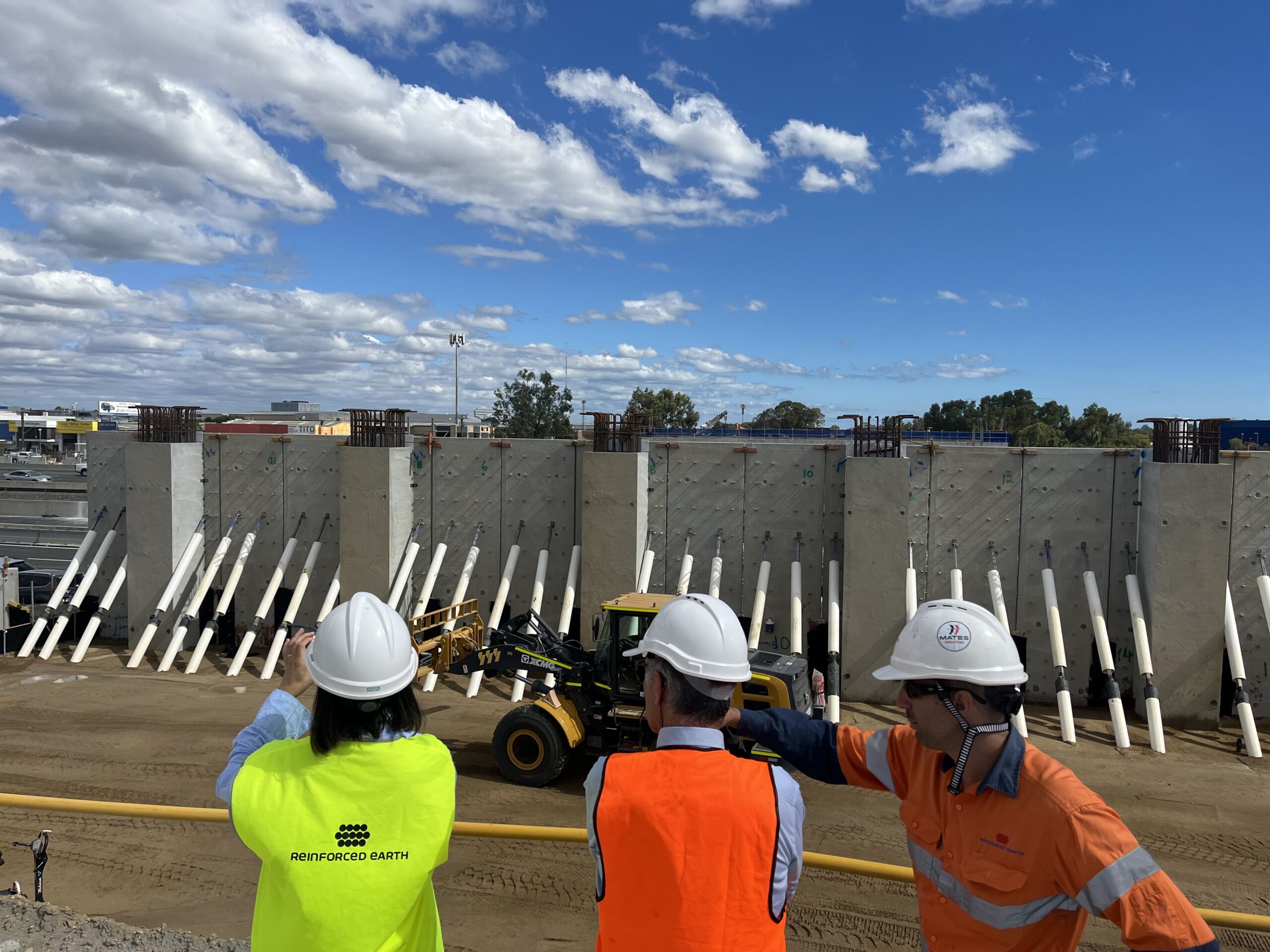 Reinforced Earth engineers in high vis vests survey precast concrete walls at the road infrastrcutrue project, Stephenson Road Extension, at Perth's Mitchell Freeway.