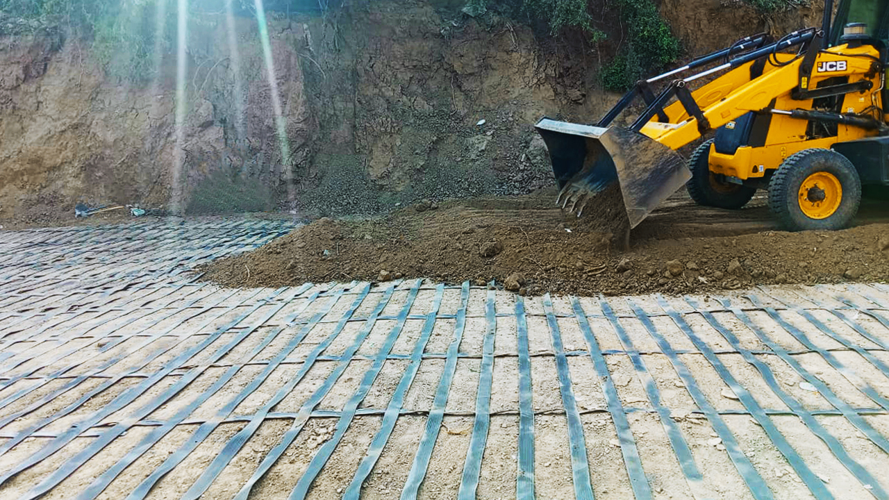 ArmaLynk, geogrid geosynthetic being installed on site using machinery.