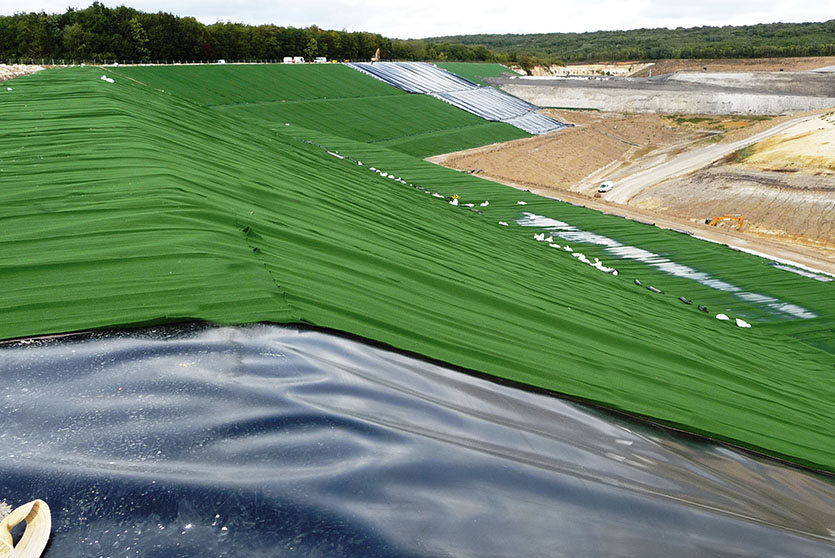 The geotextile, TechRevetment™ formed concrete mattresses, part of the geosynthetics solutions for erosion control. Pictured on the side of a lake.